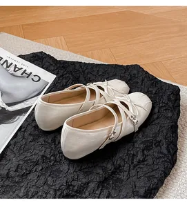 Detailansicht cremeweißer Mary Jane Ballerinas mit Kreuzgurten und süßen Schleifen