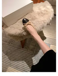 Detalle de bailarinas bicolores con lazo, mostradas puestas en un ambiente de estilo