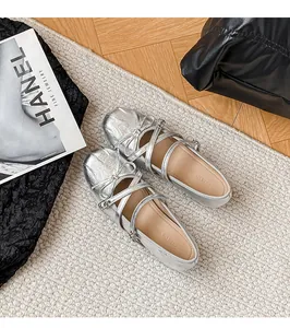 Nahaufnahme silberner Mary-Jane-Schuhe im Ballett-Stil mit Schleife und Riemen