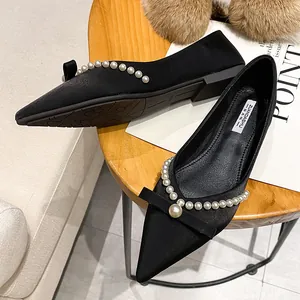 Elegant black pointed-toe flat shoes with pearl and bow details available in large sizes