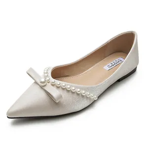 Elegant cream pointed toe flats with pearl bow and satin finish for women.