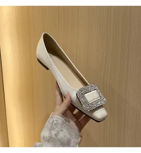 Nahaufnahme eines eleganten Satin-Flachschuhs mit einer kristallbesetzten Schnalle