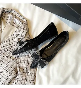 Scarpe ballerine nere a punta con fiocco di strass e finitura con paillettes nere.