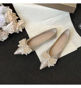 Dettaglio ballerine a punta color champagne con fiocco di strass e finitura glitterata