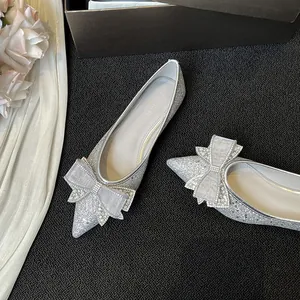 Eleganti ballerine a punta argento con fiocco di strass su sfondo nero strutturato