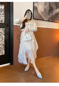 Light blue pointed-toe Mary Jane shoes with floral details worn by a model in white