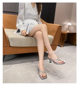 Elegant silver rhinestone high-heeled sandals with square toe shown in indoor setting