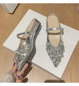 Detailansicht silberner spitzer flacher Mules mit Strasssteinen und Perlenbogen
