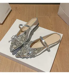 Detailansicht silberner Pantoletten mit luxuriösem Strass- und Perlenbogen-Dekor