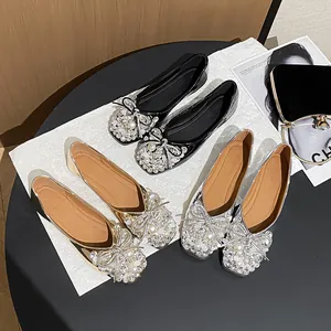 Elegant ballet flats with pearl and rhinestone bow details in black, gold, and silver.