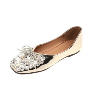 Elegant gold bridal flat shoes featuring sparkling rhinestone and pearl bow decoration