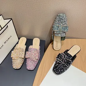 Elegant flat pointed-toe mules with sparkling rhinestones and pearl buckle detail