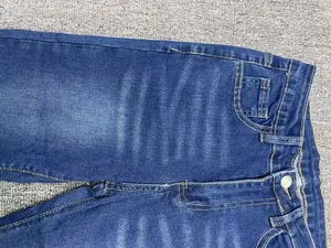 Vista dettagliata di jeans a zampa in denim elasticizzato blu scuro con lavaggio baffi