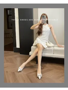 Eleganti ballerine bianche a punta con fiocco indossate da una modella in foto lifestyle