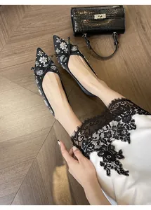 Dettaglio ballerine nere a punta con fiocchi di strass e decorazioni floreali