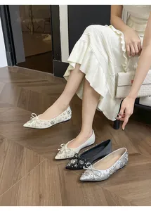 Eleganti ballerine a punta con fiocco di strass in bianco, nero e argento.