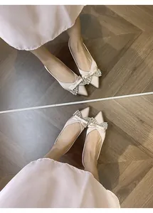 Dettaglio ballerine a punta in raso champagne con fiocchi di strass scintillanti