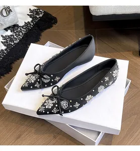 Eleganti ballerine nere a punta con decorazioni di fiori in strass e un fiocco nero.
