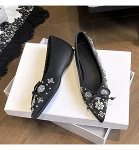 Dettaglio di ballerine nere a punta con eleganti e luminosi motivi floreali strass.