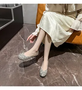 Elegante champagnerfarbene Ballerinas mit Strass und Schleife an einem Model in Luxusumgebung