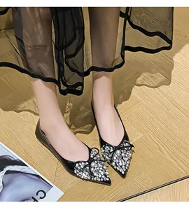 Eleganti ballerine a punta nere con fiocchi di strass scintillanti e perle.