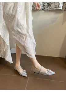 Detail view of elegant light grey pointed toe Mary Jane flats with floral pearl accents
