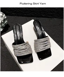 Elegant silver rhinestone straps on black high-heeled sandals shown in detail.