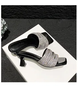 Detailed view of elegant black high-heeled sandals with silver rhinestone straps