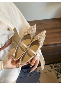 Detail of beige Mary Jane flats with elegant fabric roses and crystal embellishments