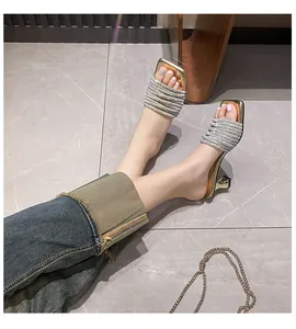 Elegant silver high heel mules with sparkling rhinestones shown on feet for summer.