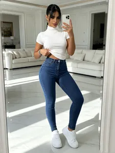 Full view of high-waist skinny stretch denim pants styled with a white crop top