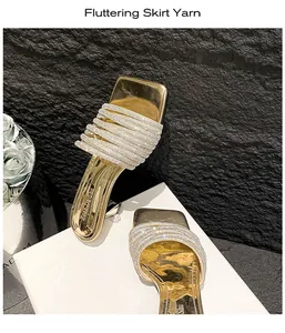 Detailed view of elegant gold heeled sandals featuring sparkling rhinestone straps