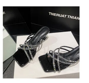 Detailed view of elegant black high-heeled sandals with sparkling rhinestone straps
