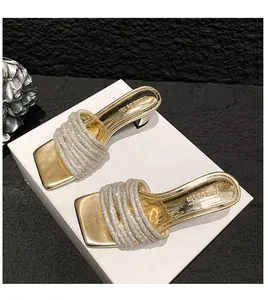 Elegant gold high-heeled sandals featuring many sparkling rhinestone-encrusted straps.