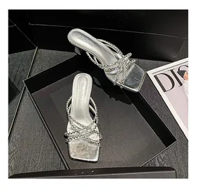 Elegant silver high-heeled sandals with sparkling rhinestone straps in a black gift box