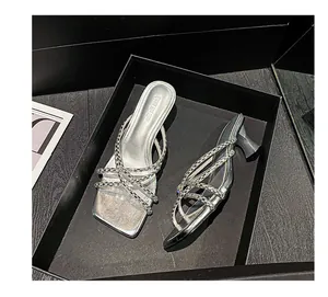 Detailed view of silver rhinestone high heel mules presented in a luxury black gift box