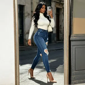 Jean skinny déchiré à taille haute bleu foncé avec ourlets effilochés pour un look urbain.