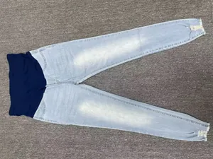 Detail view of light blue maternity skinny jeans with high-waist elastic belly support band