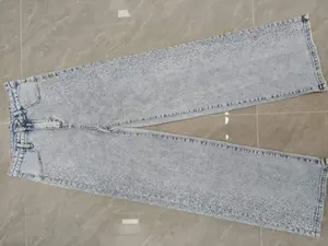 Gros plan sur un jean bleu clair à jambes droites avec des strass étincelants
