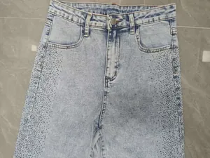 Gros plan d'un jean taille haute avec des détails de strass brillants sur les côtés