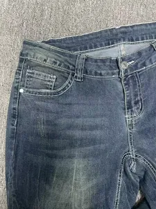 Dettaglio macro di jeans a vita bassa blu scuro con cuciture bianche a contrasto retrò