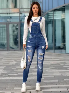 Detailed full view of women's distressed denim skinny overalls with stylish ripped details
