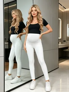 Full-length view of white maternity skinny jeans featuring a supportive belly panel