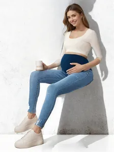 Detailed view of slim maternity jeans featuring high elasticity belly support in blue wash