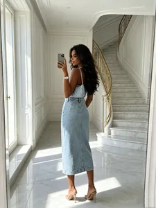 Detailed back view of a light blue washed denim midi skirt in a luxury home interior