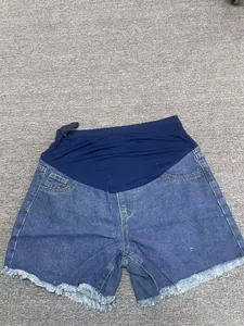 Vue à plat de shorts en jean de maternité avec bande élastique de soutien du ventre.