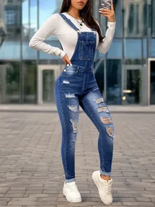 Full-body view of slim fit women's distressed denim overalls with ripped details