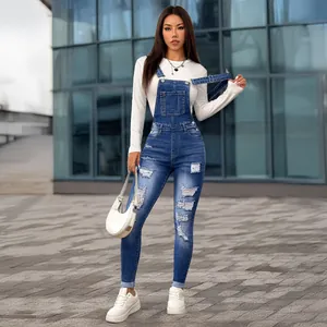 Detailed view of slim fit distressed denim overalls worn by an Asian model outdoors