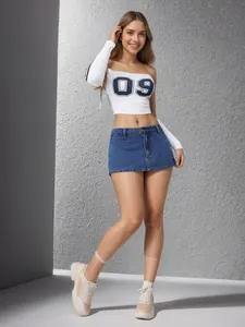 Stylish women's vintage blue denim mini skirt with a sporty white long-sleeve crop top.