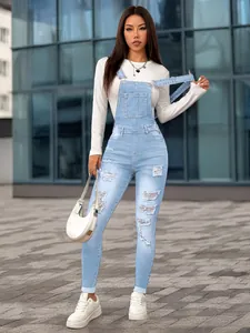 Full body view of slim light blue distressed denim overalls with a trendy ripped design